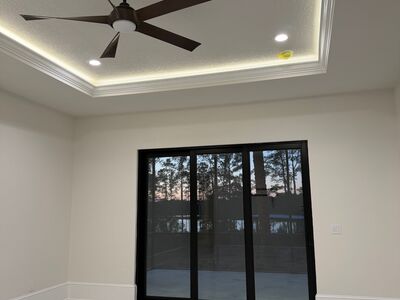 Medium room with a brown ceiling fan and large vertical windows